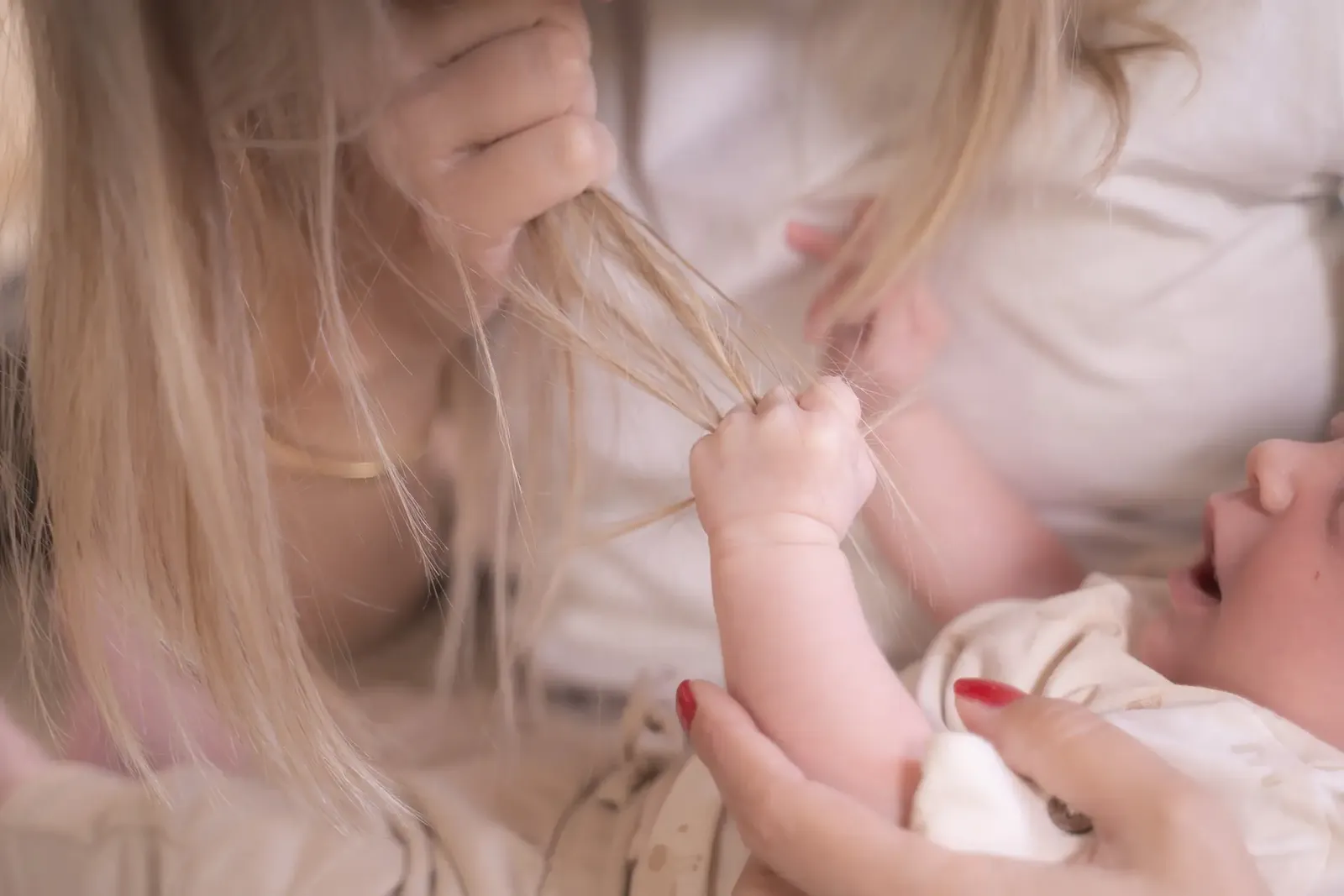Babyhandje houdt mama's haar vast